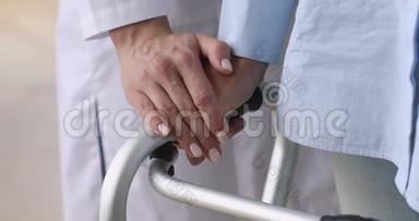 女护士用步<strong>行架</strong>握住老病人的手，特写